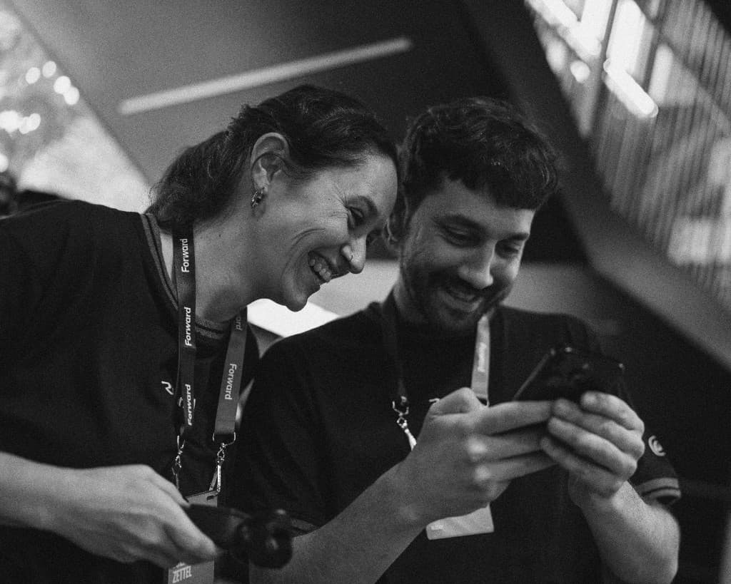 Two Resend crew members laughing at a phone